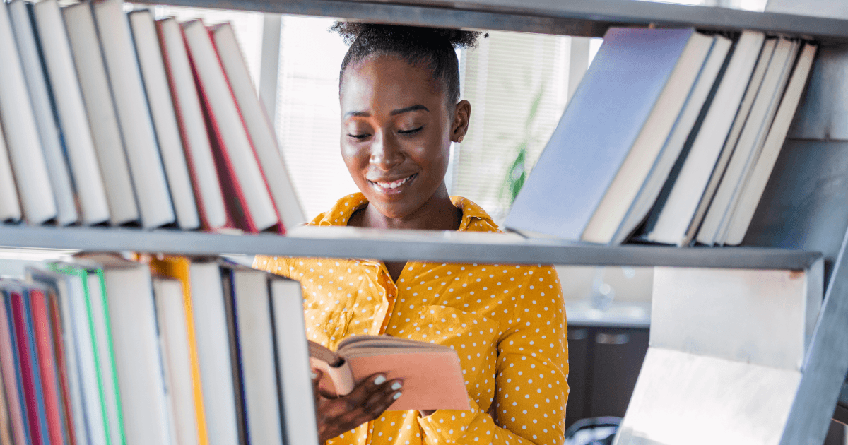 Woman browsing the shelves for books in a library.